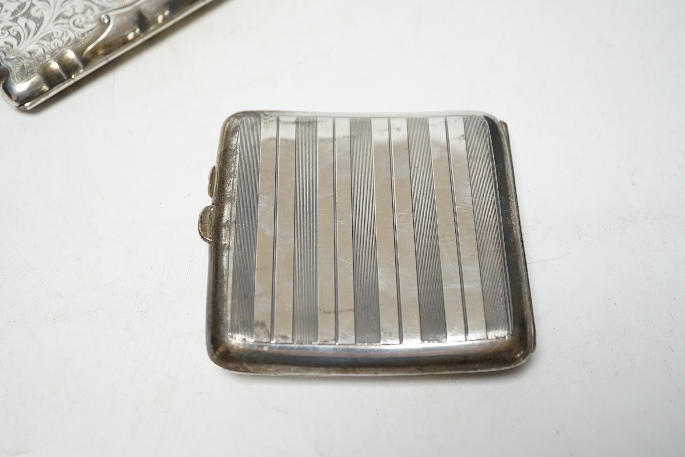 A George V silver cigarette case, 94mm and a George V engraved silver purse (lacking insides). Condition - poor to fair